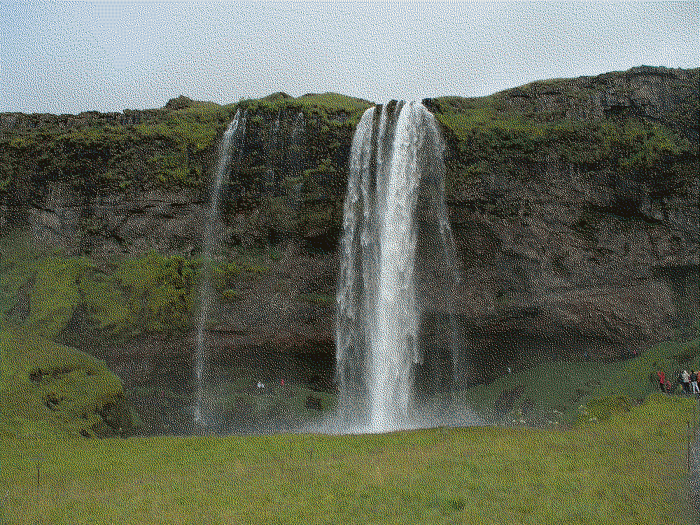 A large waterfall sends the current tumbling magnificently down over a large cliff face.